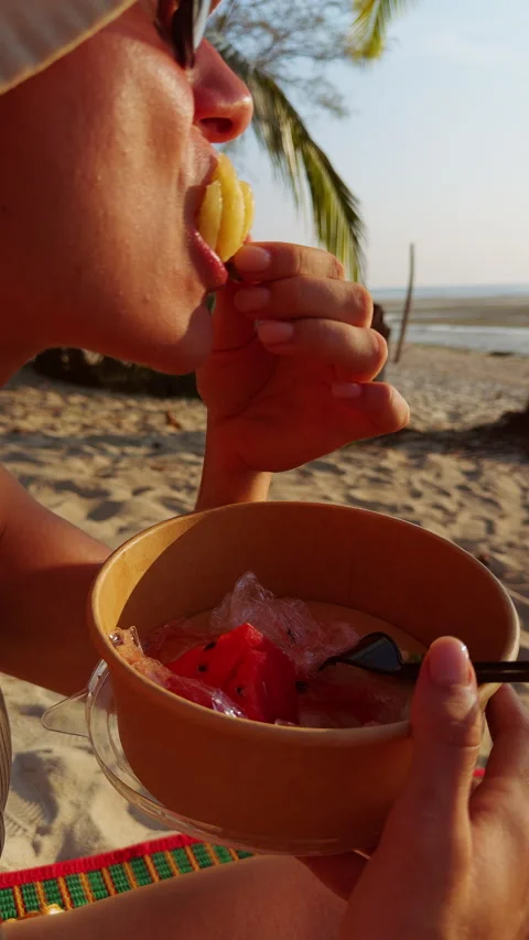 Vertical video. Close Up Side View Of Woman Eating Mini Pineapple Slice From Bow 库存影片 332296246