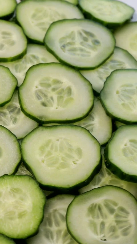Vertical video. close-up of sliced cucumber pieces. Rotating fresh cucumber Stock Footage 304682788