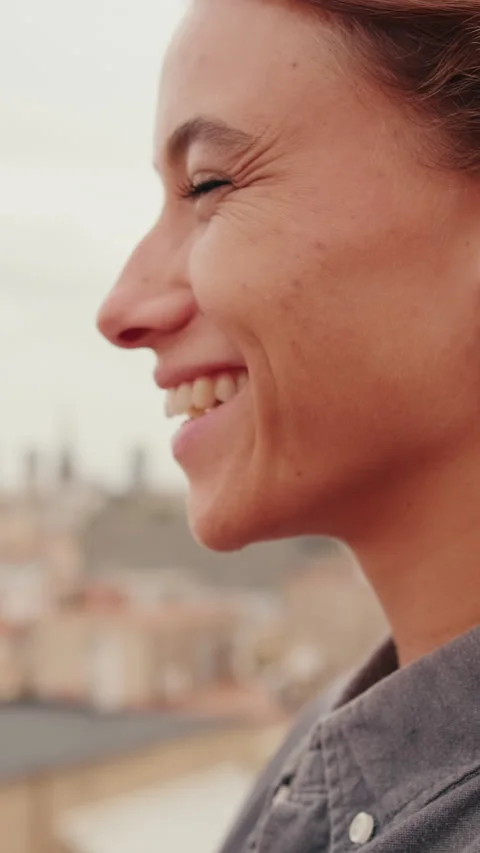 Vertical video, Close up, smiling young woman standing on balcony looking at Stock Footage 308814234