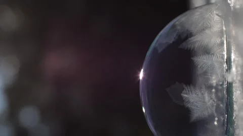 Vertical video. Close-up. A soap bubble freezes in the rays of the winter sun. Video stock 260838573