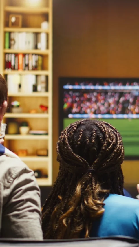 Vertical video Close up of soccer supporters eating popcorn on sofa during match Stock Footage 338185019