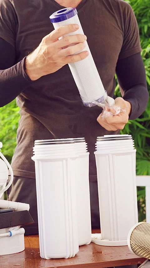 Vertical video. Close Up Unpacking New Water Filter Cartridge for Reverse Osmosi Stock Footage 335214601