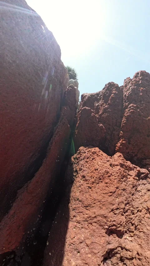 Vertical video. Close View Of Narrow Gap Between Reddish Brown Rocks With Small 動画素材 313251533