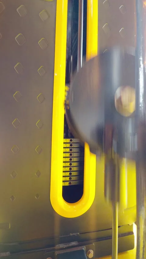 Vertical video. Close-Up of Weight Stack with Yellow Trim and Measurement Stock Footage 319268459