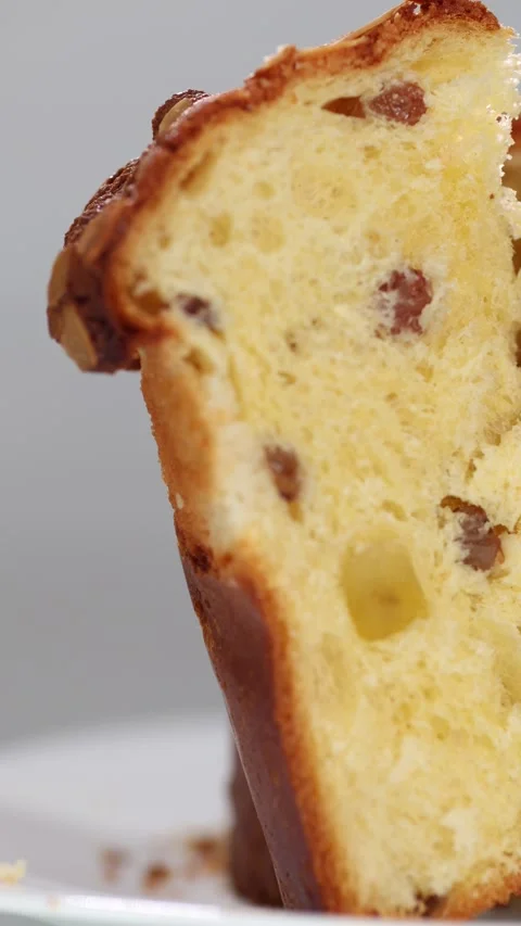 Vertical video. Close-up on a white plate a piece of Easter bread panettone. Video stock 304271164