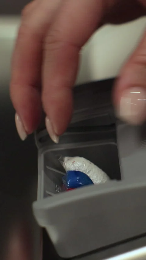 Vertical video. Close up woman adding rinse aid tablets detergent. Woman Video stock 347578920