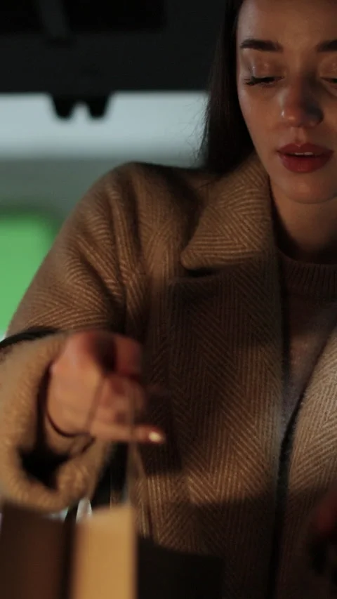 Vertical video Close-up woman opens the trunk of car and puts paper bags. Stock Footage 339574185