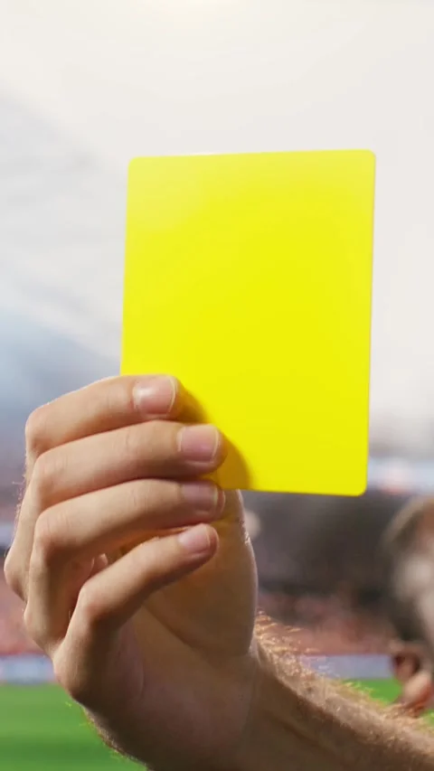 Vertical Video Close-up of yellow card held by referee hand after rules Stock Footage 338046923