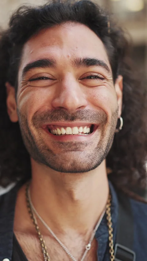 VERTICAL VIDEO: Close-up of young attractive italian guy with long curly hair an Stock Footage 226949567