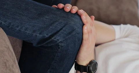 Vertical video: Close up of young man touching his knee feel pain and doing Stock Footage 271506990