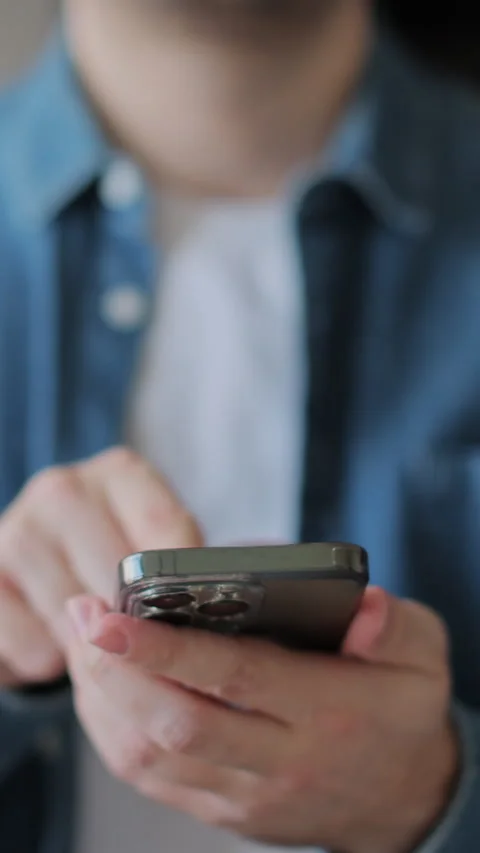 Vertical video Close-up young man using smartphone in living room at home. Stock Footage 338085836