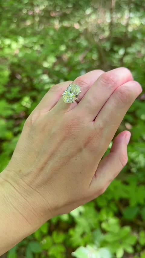 Vertical video closeup of engagement ring or wedding band in woodland light Stock Footage 316491992