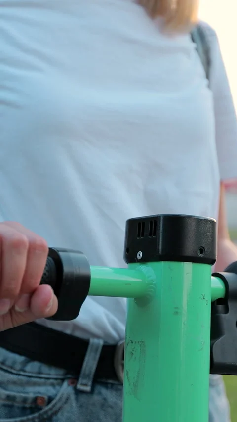 Vertical video. Closeup female hands riding electric scooter walking downtown. Stock-Footage 344431133