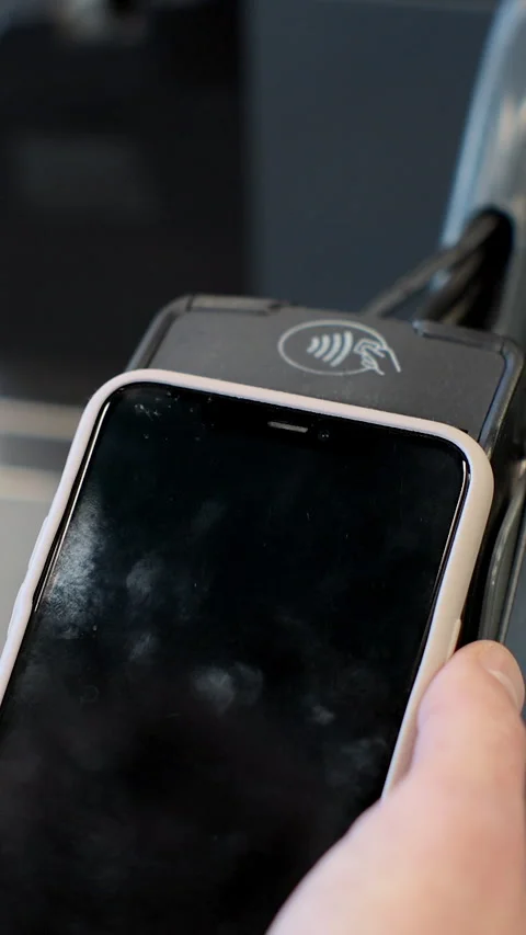 Vertical video. Closeup man paying with smartphone at the checkout counter in Stock Footage 346684863