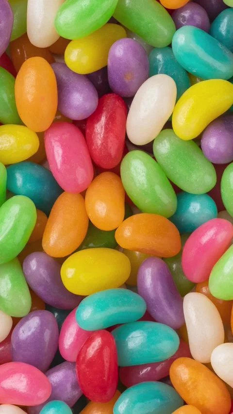 Vertical video. Closeup top view of colorful jelly beans. Candy backdrop Stock Footage 249016990