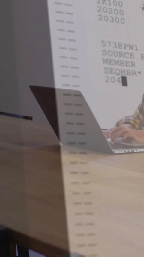Vertical video: Code appearing, forming column while seated coder typing on Stock Footage 334540570