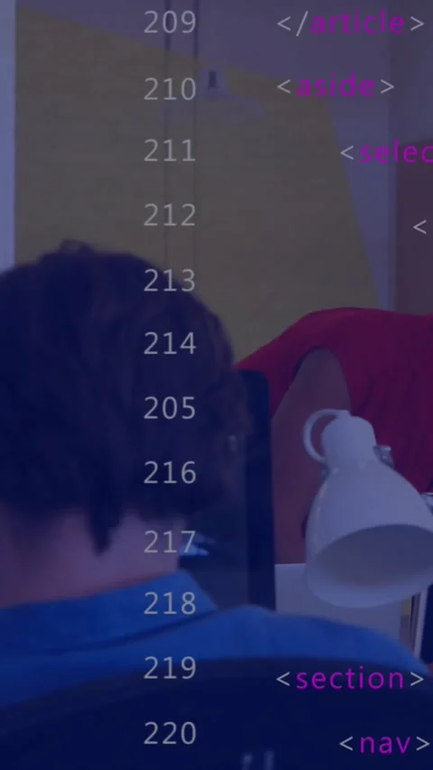 Vertical video: Coder in red leaning over peer checking code, touching arm, code Stock Footage 329876054