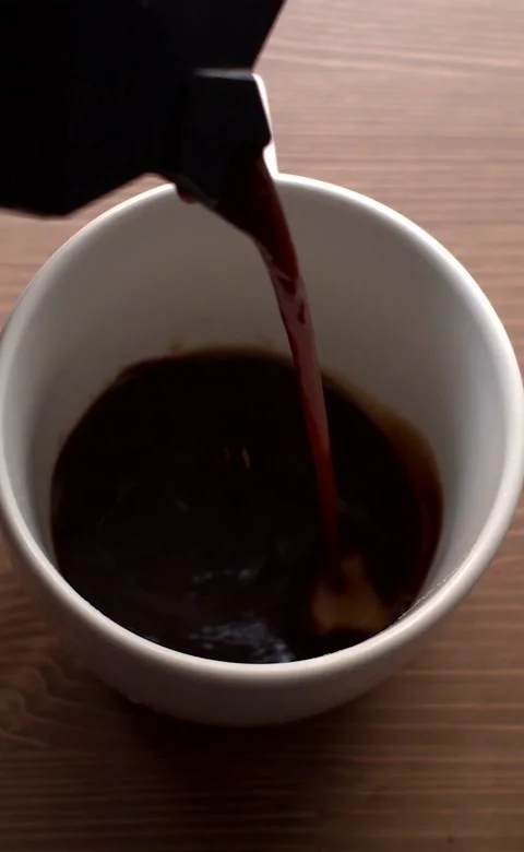 Vertical video. Coffee pot serving a cup of cage on a wooden background Video stock 224501275