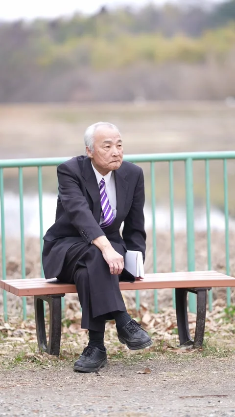 A vertical video in a cold natural park in Japan in March. A man in his 70s, in Stock-Footage 307659295