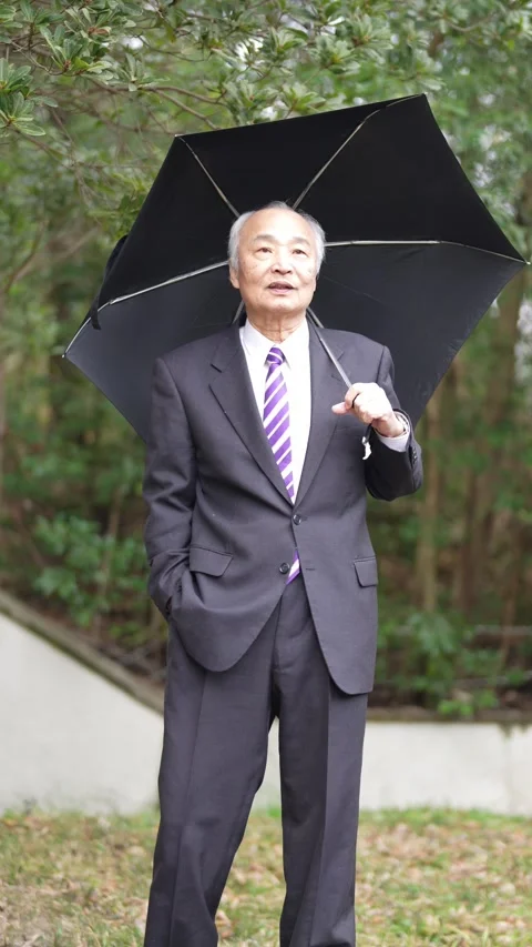 A vertical video in a cold natural park in Japan in March. A man in his 70s, in Stock Footage 307659708