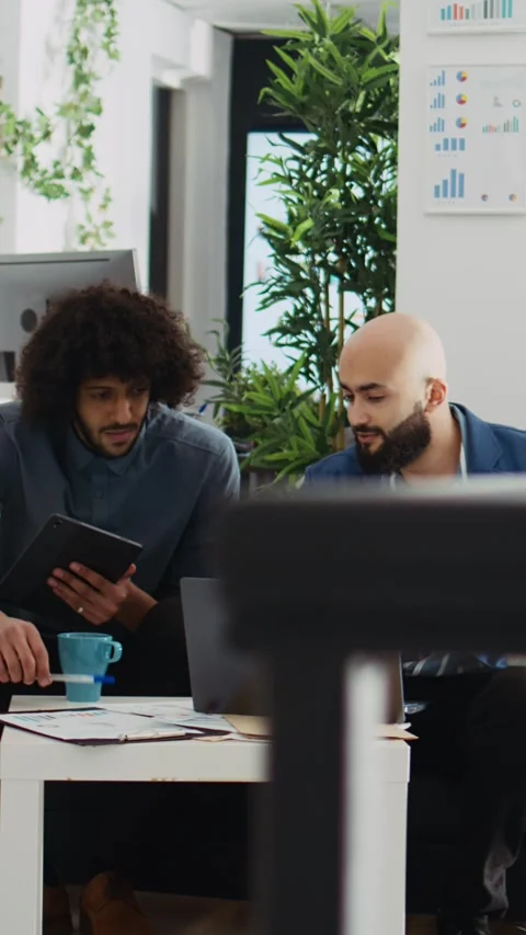 Vertical Video Colleagues comparing data analytics Stock Footage 243727219