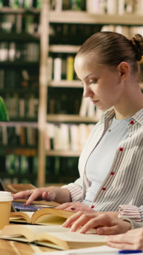 Vertical Video College students sitting in library reading books and using Stock Footage 336380045