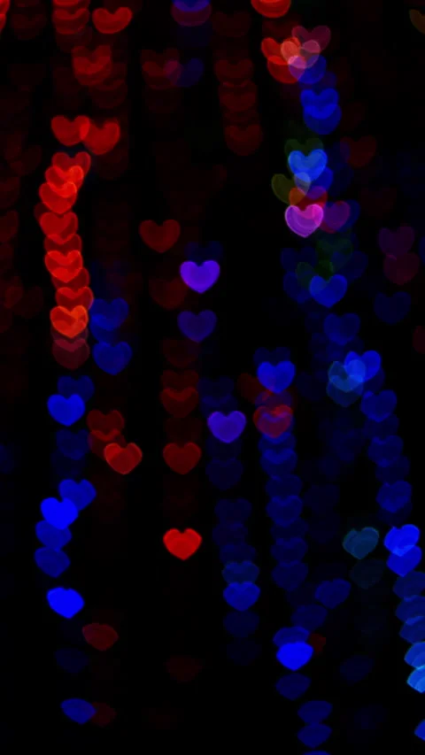 Vertical video colored heart-shaped bokeh flash in the dark background Stock Footage 253333557