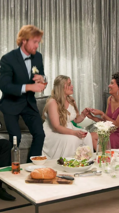 Vertical video: Confetti falling, groom standing, bride with glass, maid holding Stock Footage 334770375