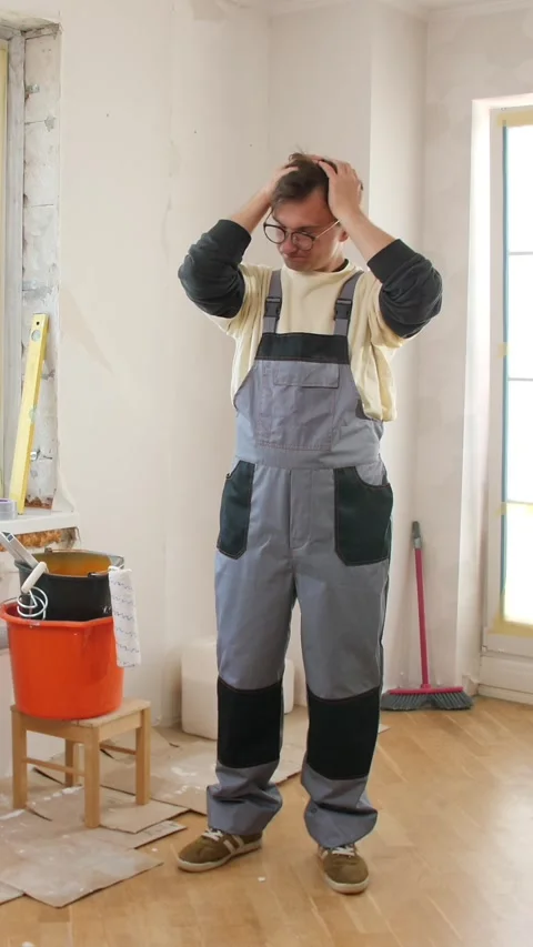 Vertical video confused construction worker touching head during home renovation Stock Footage 313275599