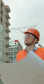 Vertical video. Construction professional analyzing project plan at buildin.. Stock Photos