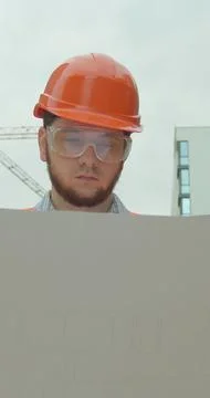 Vertical video. Construction professional analyzing project plan at buildin.. Stock Photos