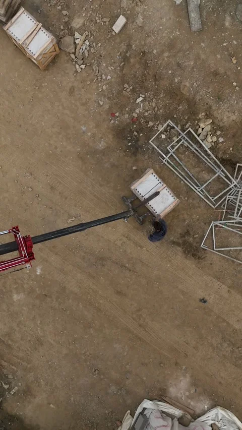 Vertical Video: Construction Site Buzz - Aerial Perspective of Crane Unloading Stock Footage 245189741