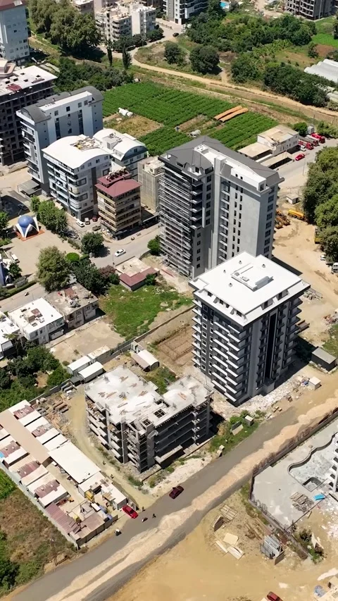 Vertical Video: Construction Site with Workers, Cranes, and Trucks Seen from an Stock Footage 297717917