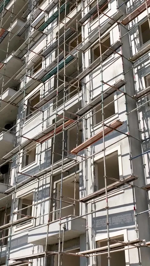 Vertical Video: Construction Workers on Scaffolding Installing Facade Panels on Stock Footage 297710486