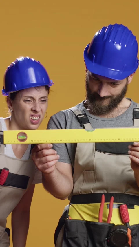 Vertical video: Construction workers using water level tools to measure flat Stock Footage 218850174
