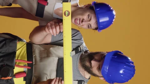 Vertical video: Construction workers using water level tools to measure flat Stock Footage 219157721