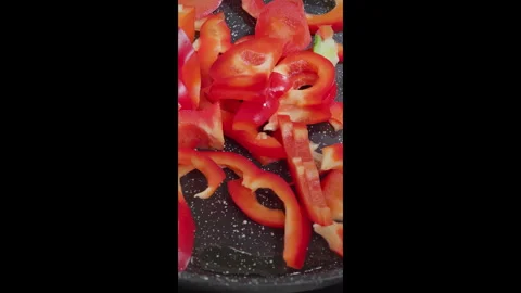 Vertical video. The cook pours red pepper into the pan. Frying the bell pepper. Video stock 302636941
