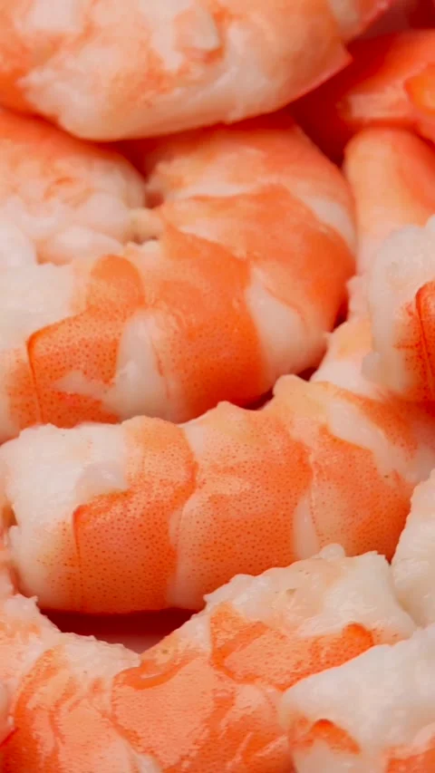 Vertical video of cooked shrimp rotating in circle with bright pink and white Stock Footage 310785691