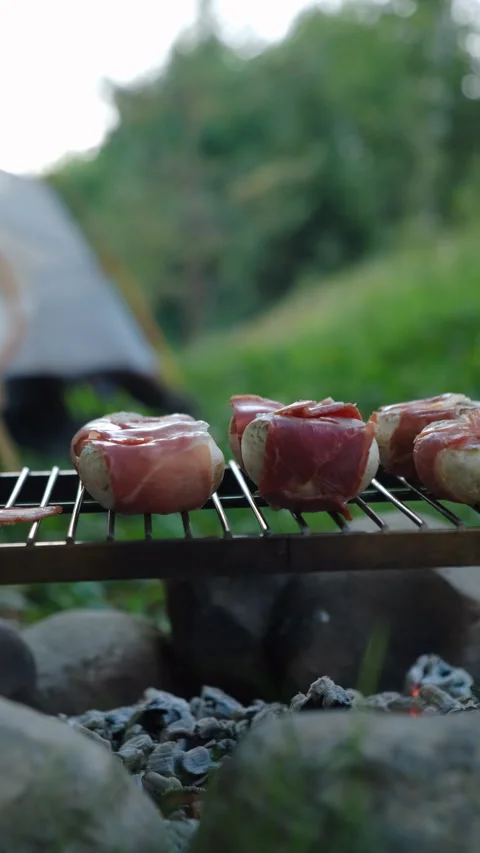 Vertical video of cooking bacon wrapped champignons grilling with smoke Stock Footage 287415347