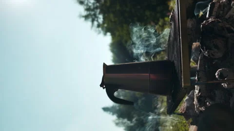 Vertical video of cooking coffee on bonfire in sunlight Stock Footage 247321103