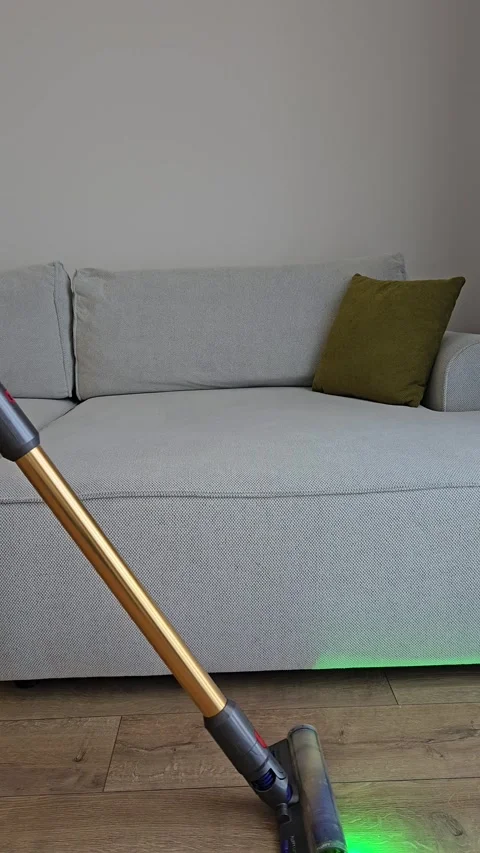 Vertical video of a cordless vacuum cleaner with light cleaning a light wooden Видео 336947746