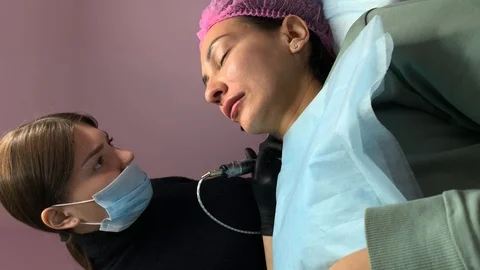 Vertical video. Cosmetologist applying permanent makeup on lips. Cosmetology  Video stock 119892669