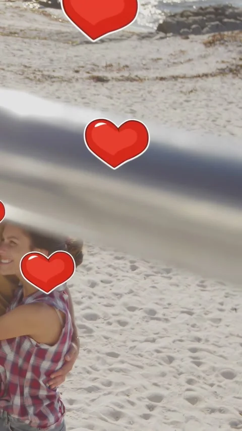 Vertical video: Couple embracing beach pan causing hearts drifting across pair Vídeo Stock 334025587