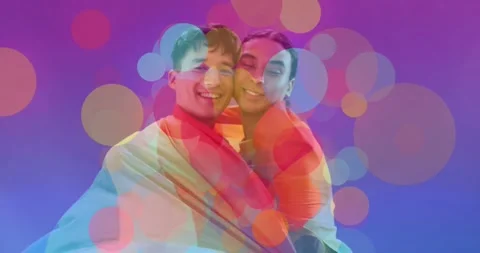 Vertical video: Couple leaning on set with bokeh rising wrapping pride flag Stock Footage 331404414