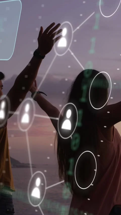 Vertical video: Couple lifting arms on shore, phone showing, sparking tech node Video stock 333840255