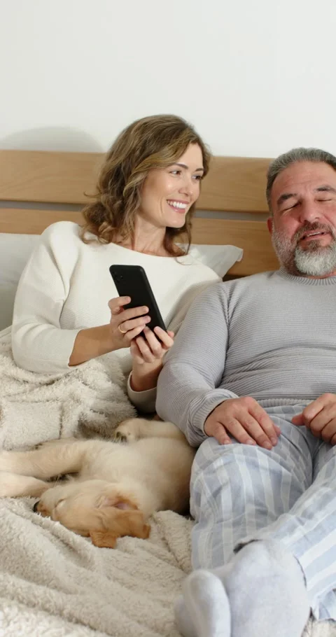 Vertical video: Couple lifting phone, scrolling feed, capturing selfie and Stock Footage 345320730