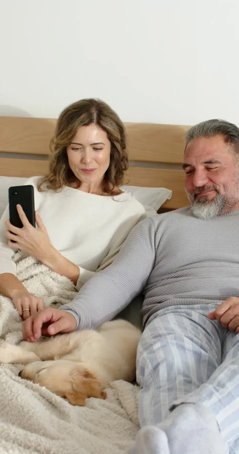 Vertical video: Couple scrolling phone and showing screen to partner while man Stock Footage 345395518