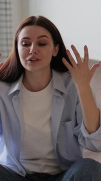 Vertical video Couple sitting on sofa in living room arguing over disagreem.. Foto stock