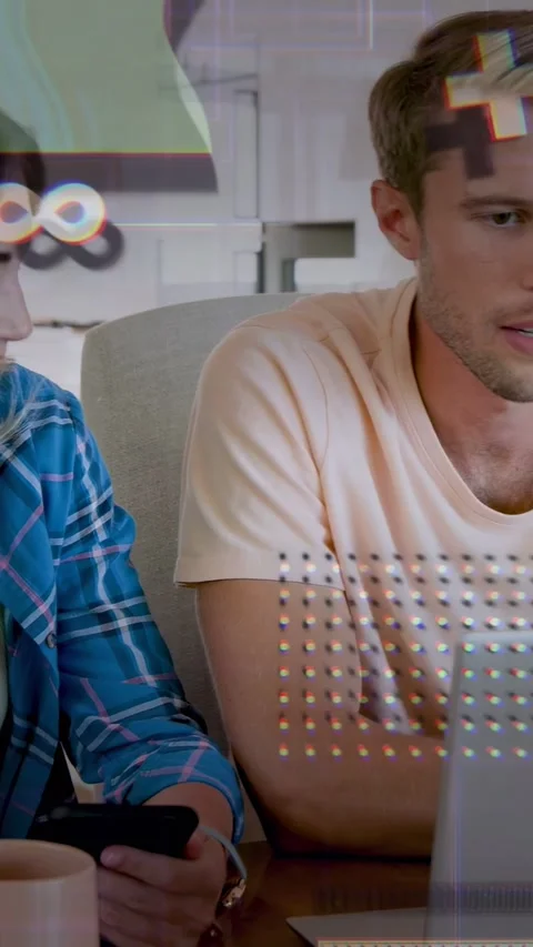 Vertical video: Couple tapping phone typing laptop doing tech work with glitch Stock Footage 333487410