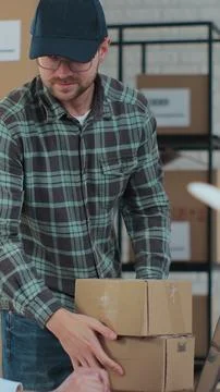 Vertical video. The courier comes to pick up the package for the customer. Fe Stock Photos